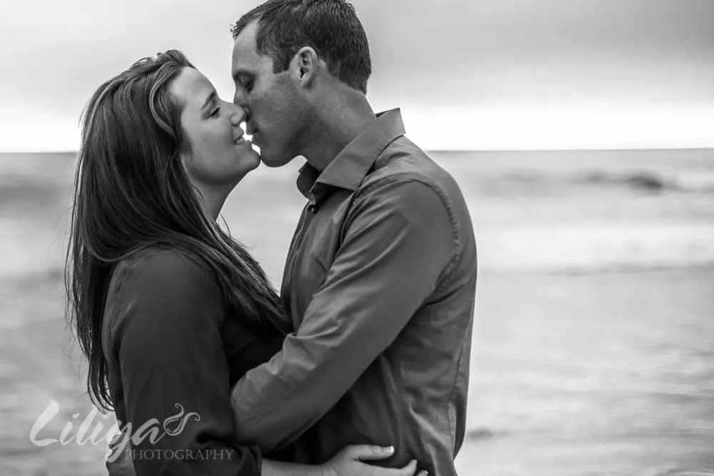 Couple kissing by the ocean, black and white