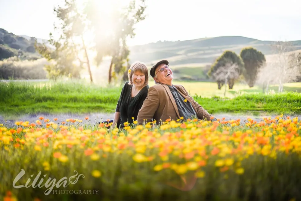 Couple lying together in a field of poppies