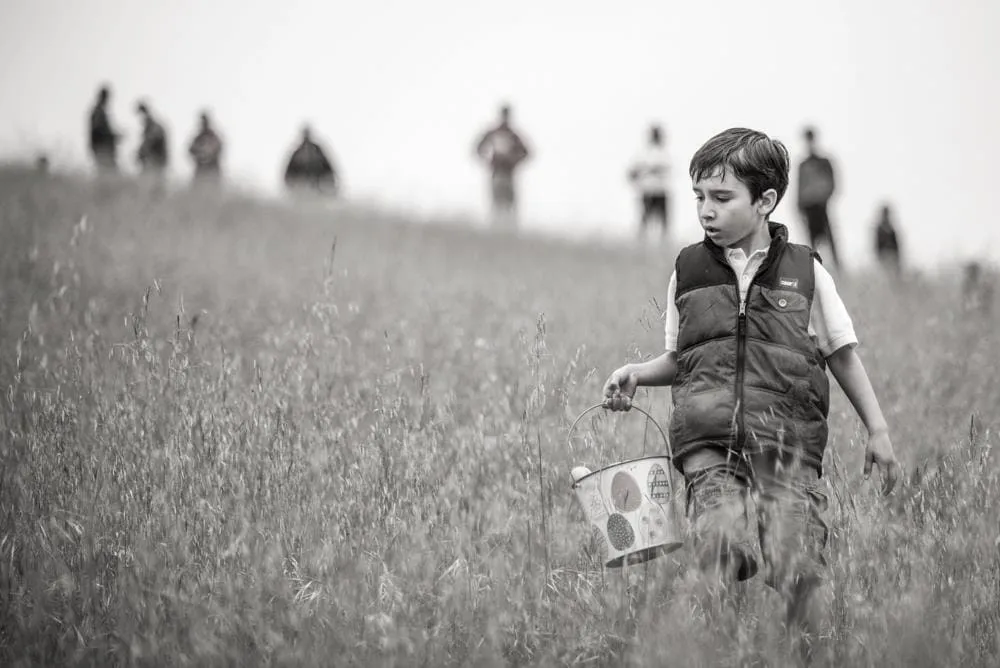 Boy running through a field, black and white