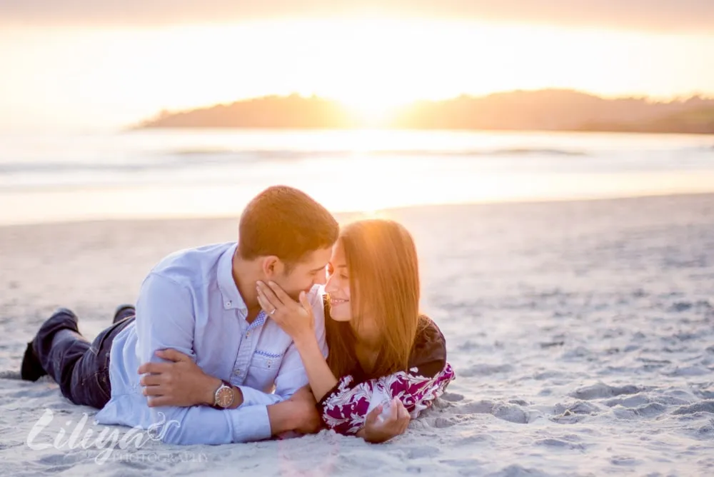 Couple lying together on the beach at sunset