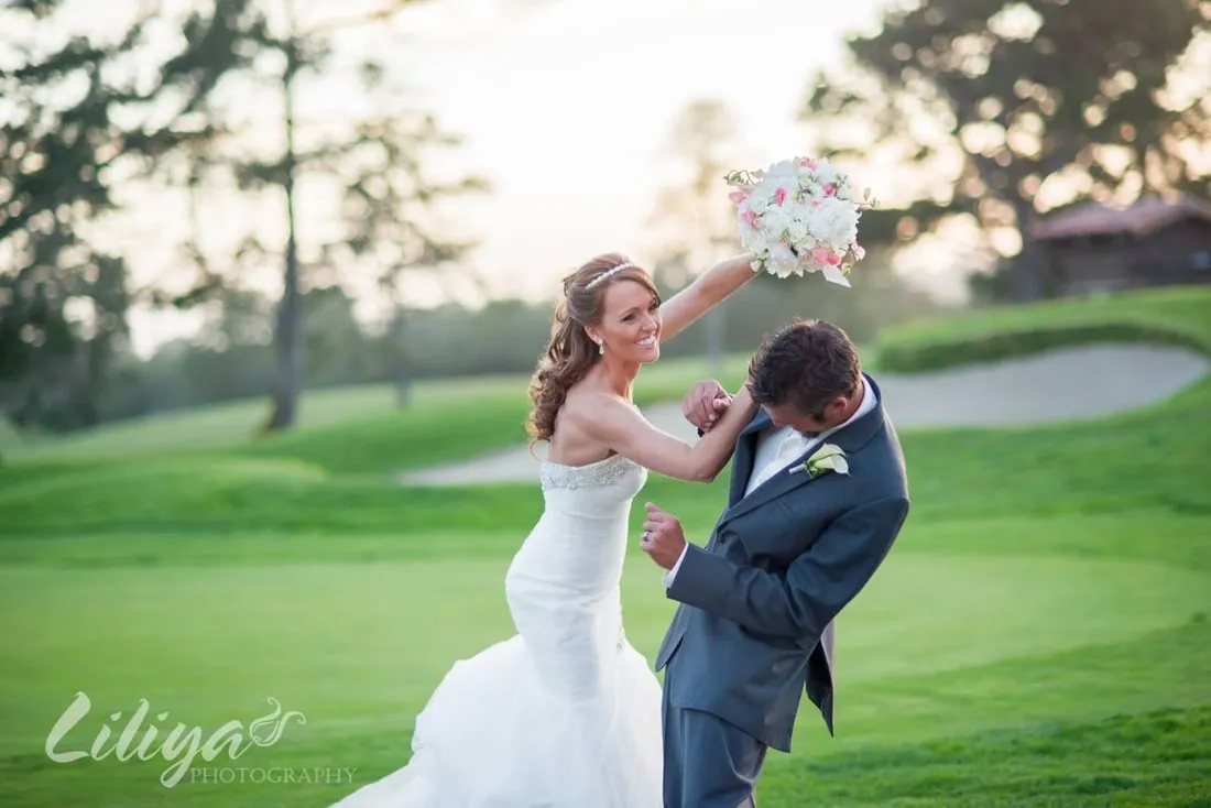 Bride and groom on the fairway, bouquet raised